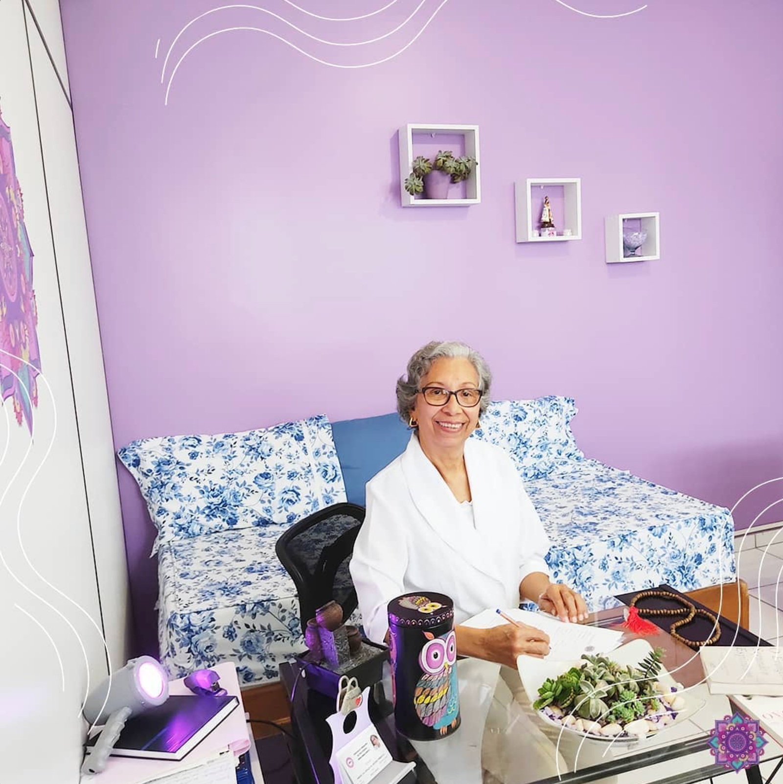 Graça Pimenta sorrindo em sua mesa dentro do Espaço Terapêutico Chama Violeta