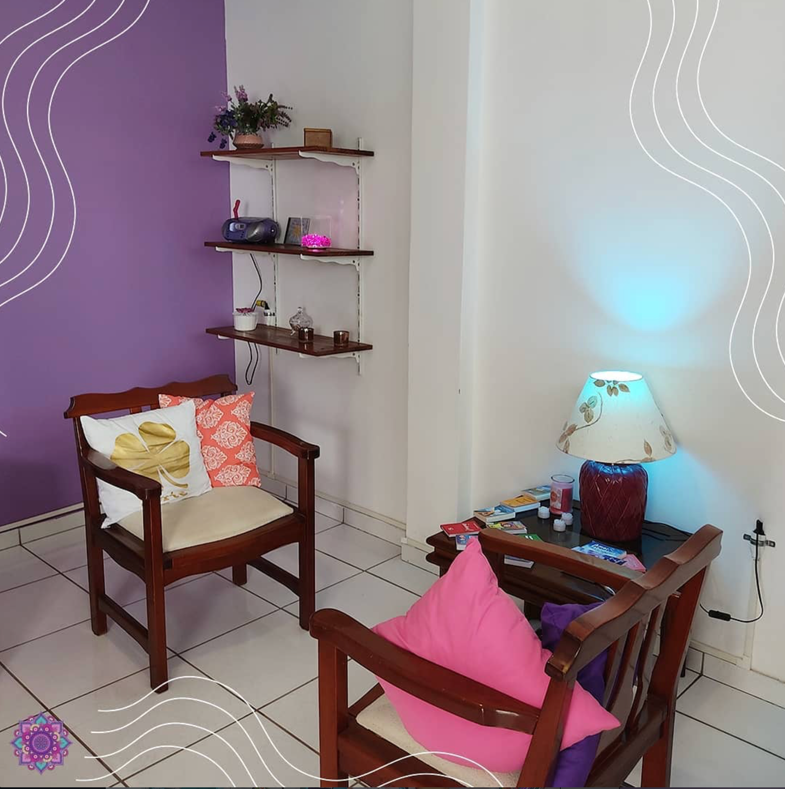 Sala interna do Espaço Terapêutico Chama Violeta com parede violeta, poltronas de madeira e luz suave